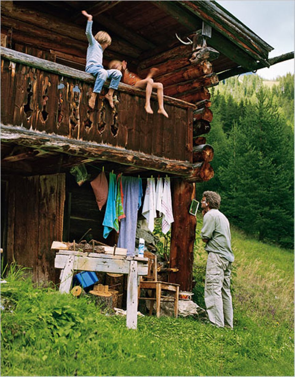 Badezimmer im Grünen: Autor Stefan Scheytt rasiert sich vor der Hütte, während die Zwillinge auf dem Balkonsofa herumtoben Badezimmer im Grünen: Autor Stefan Scheytt rasiert sich vor der Hütte, während die Zwillinge auf dem Balkonsofa herumtoben