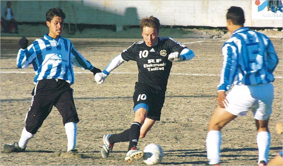 Isak Høy stürmt mit Sturmfrisur in Richtung gegnerisches Tor – auf einem Fußballfeld aus Sand
