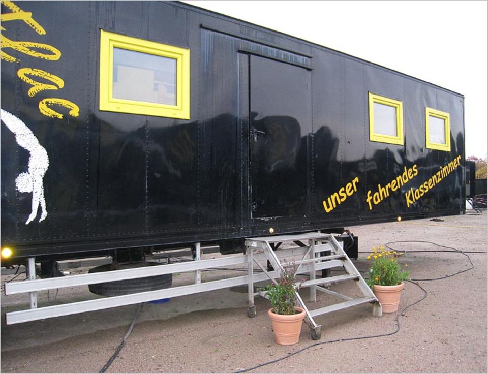Und so sieht die FlicFlac-Schule von außen aus. Sie ist in einem der typischen schwarz-gelben Container des Zirkus FlicFlac untergebracht Und so sieht die FlicFlac-Schule von außen aus. Sie ist in einem der typischen schwarz-gelben Container des Zirkus FlicFlac untergebracht