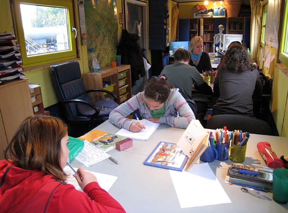 Konzentriert sitzen die Schüler mit ihrer Lehrerin im fahrenden Klassenzimmer über den Aufgaben. Hier werden alle Altersklassen gemeinsam unterrichtet Konzentriert sitzen die Schüler mit ihrer Lehrerin im fahrenden Klassenzimmer über den Aufgaben. Hier werden alle Altersklassen gemeinsam unterrichtet