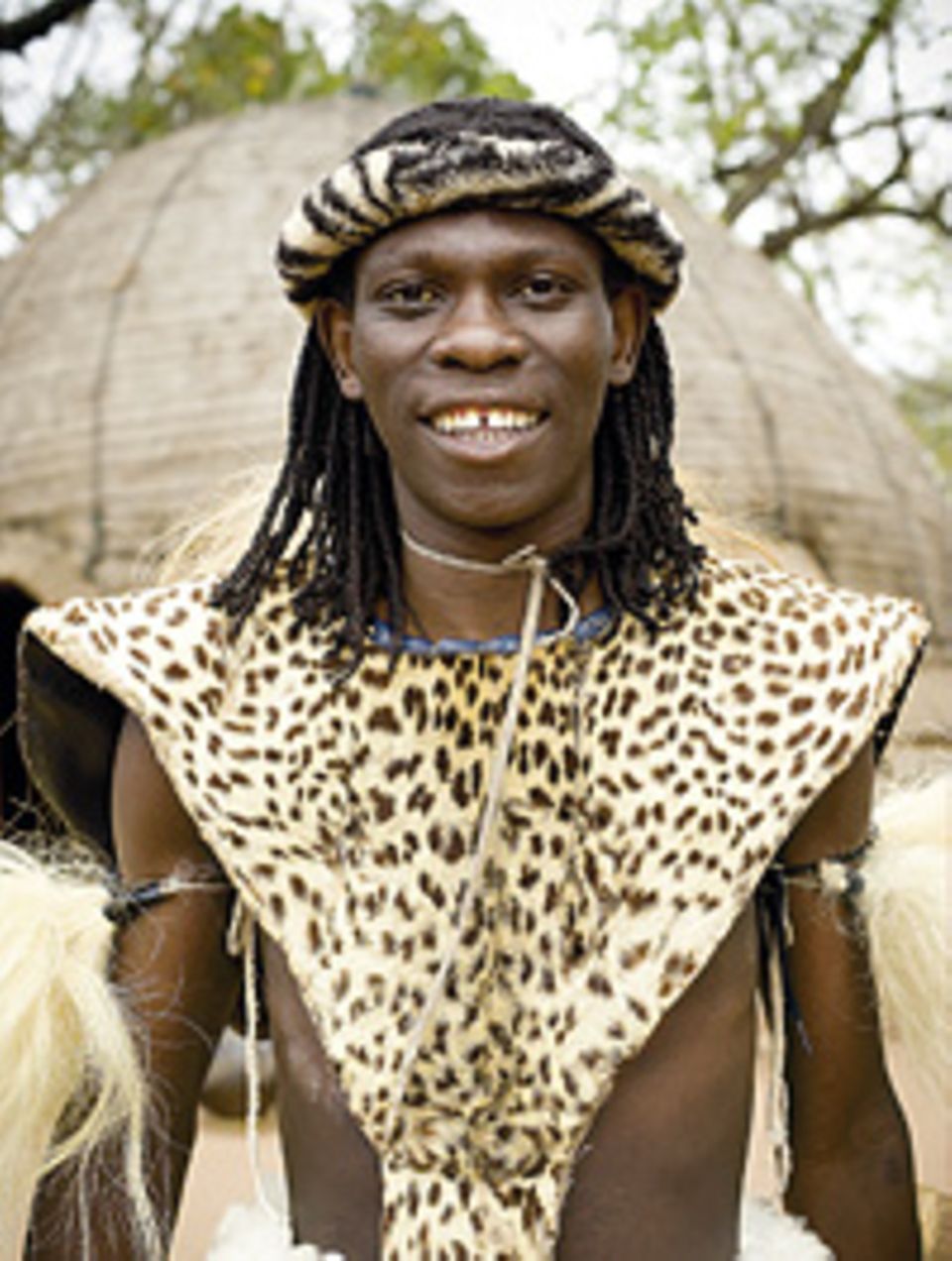 Südafrika: Ein Mann vom Zulu-Stamm zeigt Touristen seine traditionelle Tracht Südafrika: Ein Mann vom Zulu-Stamm zeigt Touristen seine traditionelle Tracht