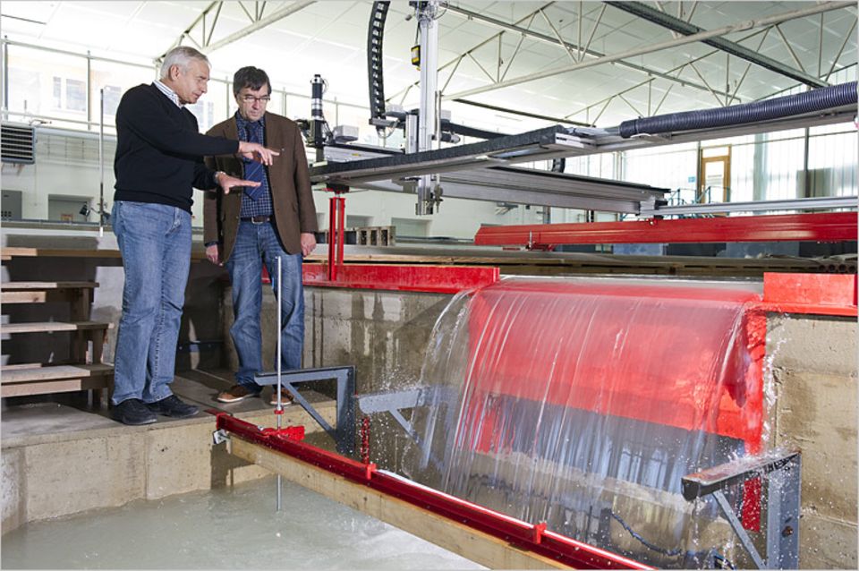 Wasserkraft: Peter Rutschmann (l.) und Albert Sepp am Modell des Kraftwerks. Eine Klappe im Wehr lässt Wasser - und damit auch Fische - passieren. Das Kraftwerk befindet sich in einer Kiste vor dem Wehr