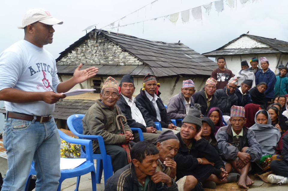 Bewohner der Bergsiedlung Pasagaun bei einer Informationsveranstaltung mit einem Mitarbeiter des Projektträgers ACAP