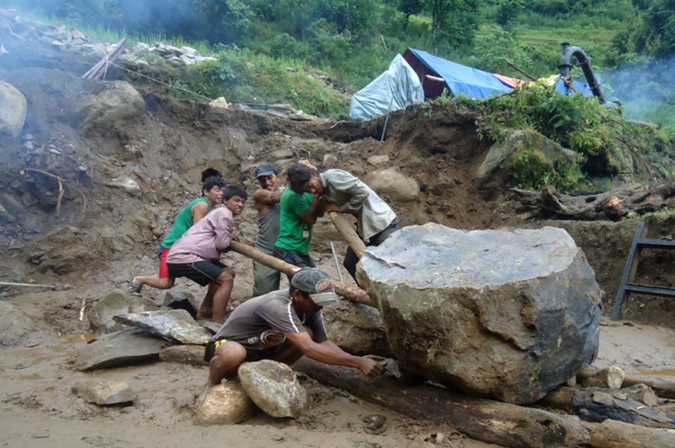 Schwere Felsbrocken müssen mit einfachsten Hilfsmitteln aus dem Weg geräumt werden.