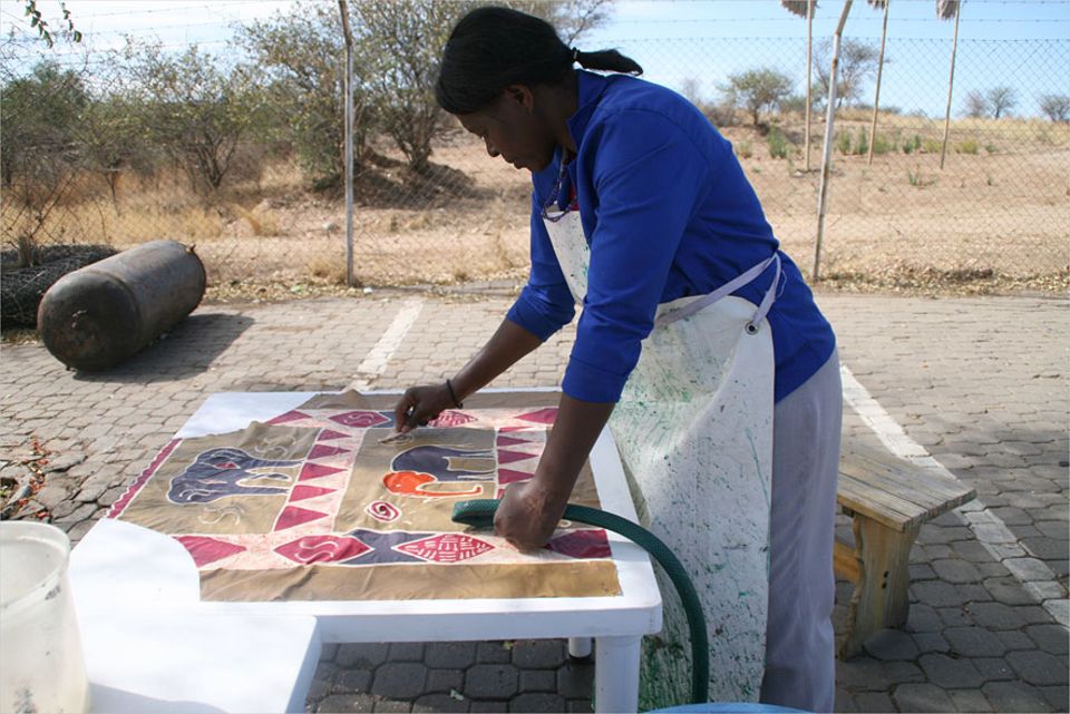Namibia: Penduka-Mitarbeiterin Viktoria fertigt eine Küchenschürze, die dann im Shop verkauft wird