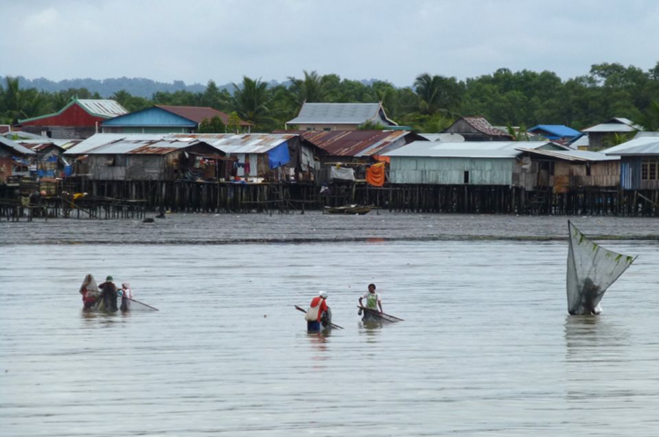 Fotogalerie zum Projekt: Bewohner des Hafengebiets von Sorong, Neuguinea, fischen im seichten Wasser mit Handnetzen