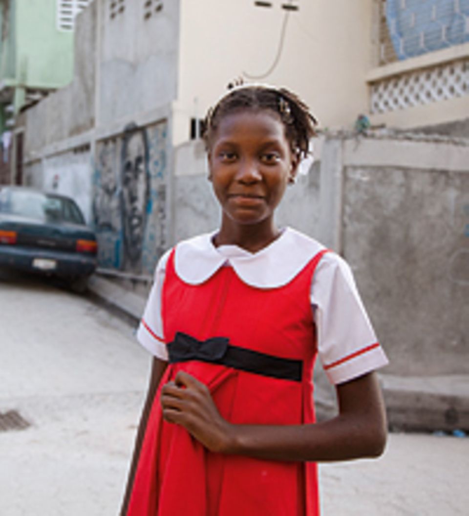 Landa lächelt: In ihrer Straße in Port-au-Prince posiert sie in ihrem Lieblingskleid. Nach dem schweren Beben 2010 lag in der Stadt kaum ein Stein mehr auf dem anderen. Die meisten Häuser waren zerstört Landa lächelt: In ihrer Straße in Port-au-Prince posiert sie in ihrem Lieblingskleid. Nach dem schweren Beben 2010 lag in der Stadt kaum ein Stein mehr auf dem anderen. Die meisten Häuser waren zerstört