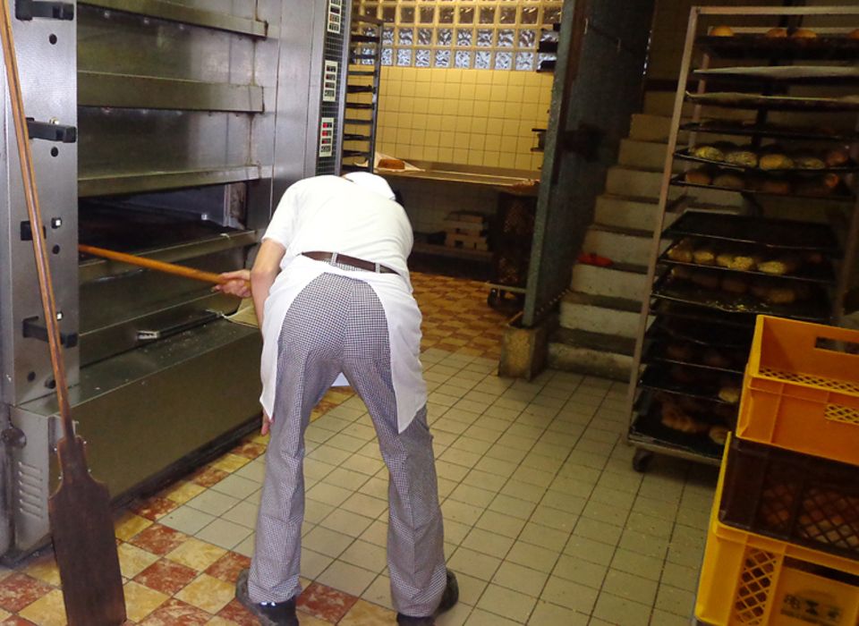 Beruf: Mit beiden Händen greift Umbach gerade nach dem großen Schieber, öffnet die Klappe des Ofens und hebt schwungvoll ein Blech frischer Brötchen heraus. Es riecht lecker Beruf: Mit beiden Händen greift Umbach gerade nach dem großen Schieber, öffnet die Klappe des Ofens und hebt schwungvoll ein Blech frischer Brötchen heraus. Es riecht lecker