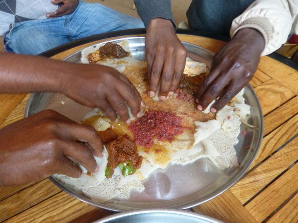 Injera wird mit verschiedenen Soßen angereichert gegessen