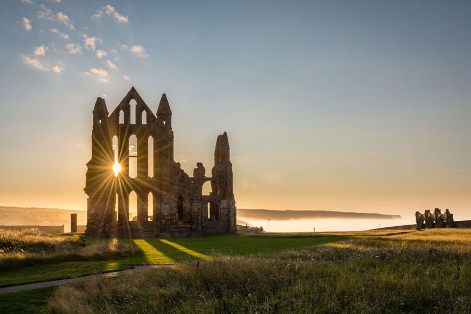 Nordengland: Die ikonische Ruine von Whitby Abbey liegt auf einem Felsen über dem Hafenstädtchen Whitby von dem aus einst Captain Cook in See stach Nordengland: Die ikonische Ruine von Whitby Abbey liegt auf einem Felsen über dem Hafenstädtchen Whitby von dem aus einst Captain Cook in See stach