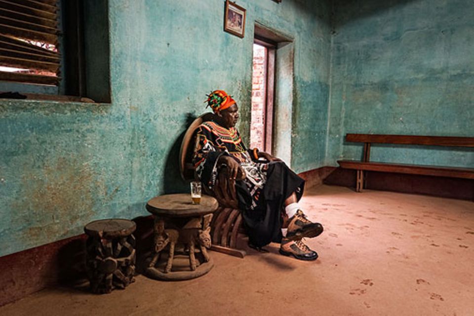 Bafut: Der traditionell gekleidete König auf seinem Thron in einem der Gebäude des Palastes. Insgesamt ist er mit acht Frauen verheiratet und ist eines von rund 300 Geschwistern Bafut: Der traditionell gekleidete König auf seinem Thron in einem der Gebäude des Palastes. Insgesamt ist er mit acht Frauen verheiratet und ist eines von rund 300 Geschwistern
