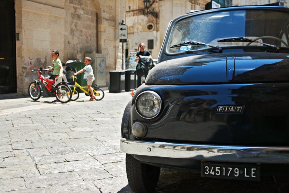 Apulien: Italienisches Straßenbild wie es im Buche steht, mit einem alten Fiat im Fokus