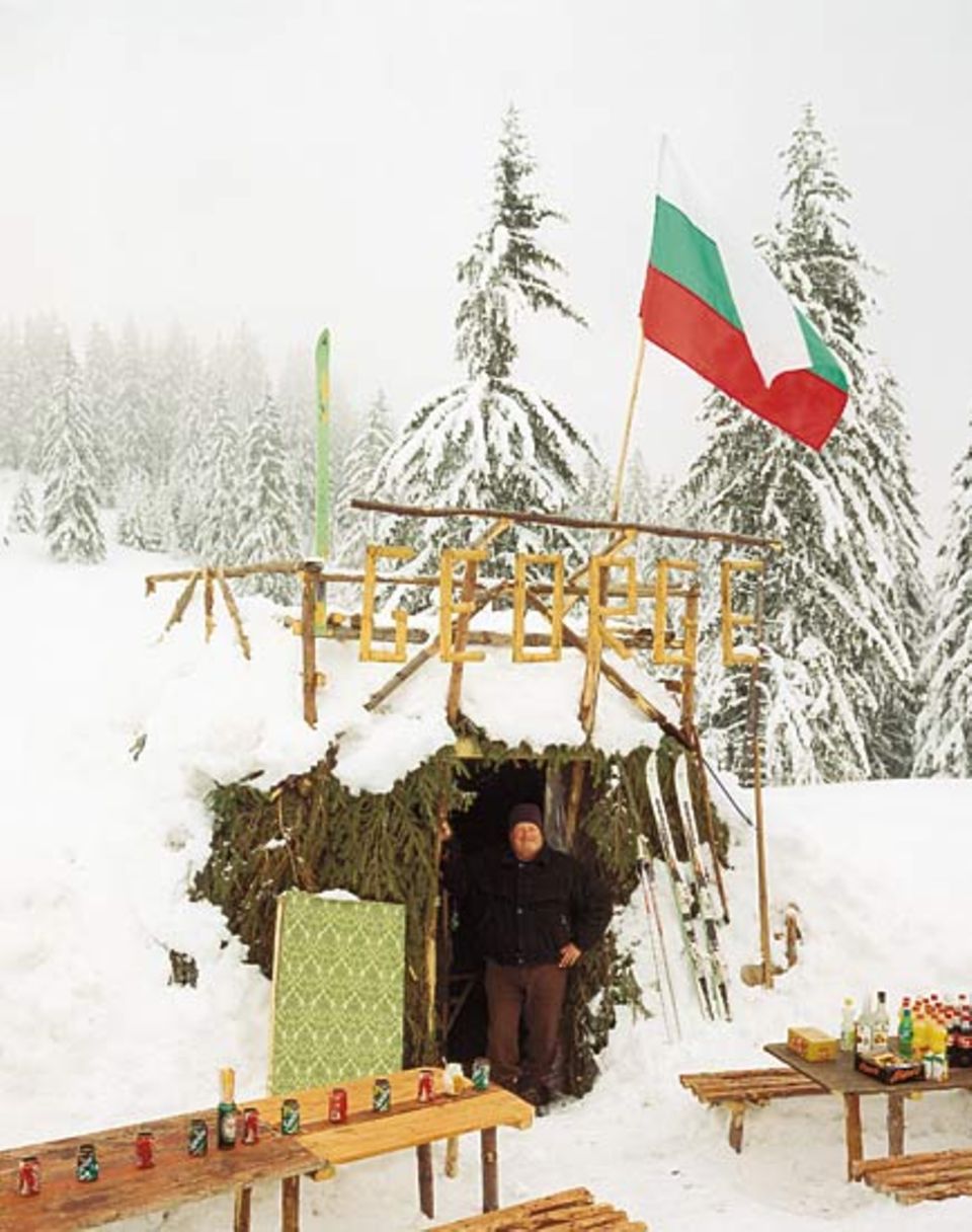 Ein Mann und seine Hütte: George ist Rentner und betreibt im Winter in Borovez eine - Jausenstation? Ski-Bar? Imbissbude? Akkurat hat er leere Dosen als Aschenbecher aufgereiht, stolz die bulgarische Flagge aufgezogen. Seine Spezialität zum Après-Ski: dampfender Kräutertee mit Honig