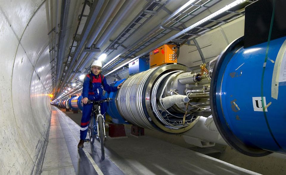 Wissenschaft: Der Teilchenbeschleuniger des CERN liegt rund 100 Meter tief im Erdboden. Fahrstühle führen hinab zu seinen beiden Ringen. Im kleineren werden die Teilchen vorbeschleunigt, ehe sie auf die 27 Kilometer lange Hauptstrecke fliegen. Bei solchen Entfernungen ist es kein Wunder, dass die Forscher mit Fahrrädern unterwegs sind