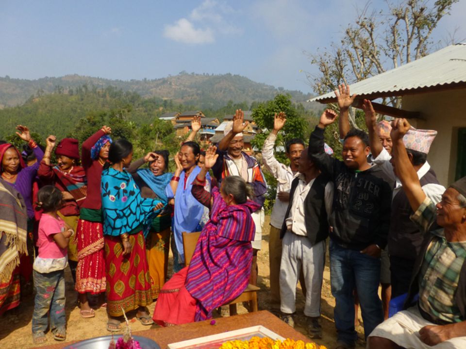 Auf einer Versammlung in der Gemeinde Maidi haben die meisten Anwesenden eine Biogasanlage wie sie stolz und lachend durch Handzeichen kundgeben