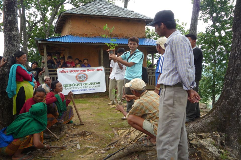 Vorbereitung für eine Pflanzaktion im Jahr 2010: Projektkoordinator Mohan K. C. erklärt freiwilligen Helfern, wie die Baumsetzlinge ausgespflanzt werden müssen, damit sie beste Entwicklungschancen haben