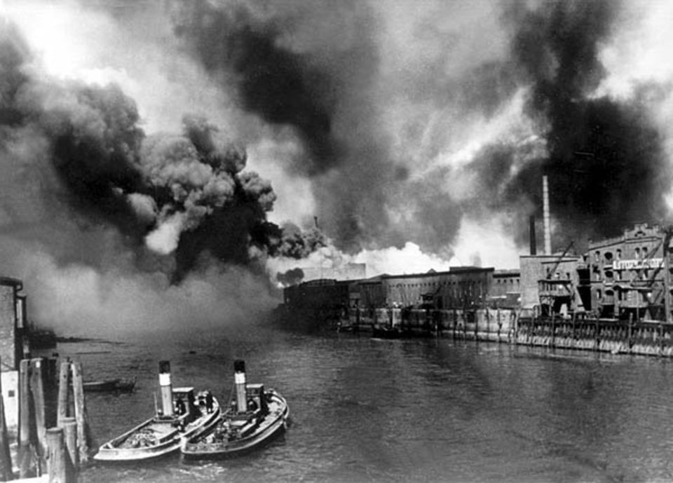 Brennende Öltanks im Hamburger Hafen nach einem Luftangriff während des Zweiten Weltkriegs Brennende Öltanks im Hamburger Hafen nach einem Luftangriff während des Zweiten Weltkriegs