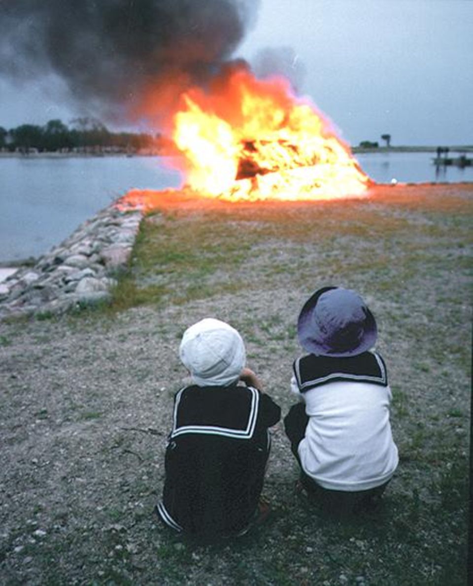 Johannisfeuer: Kinder warten im Hafen von Kuressaare bis das Feuer auf kleiner Flamme brennt. Dann dürfen sie darüber hinwegspringen Johannisfeuer: Kinder warten im Hafen von Kuressaare bis das Feuer auf kleiner Flamme brennt. Dann dürfen sie darüber hinwegspringen