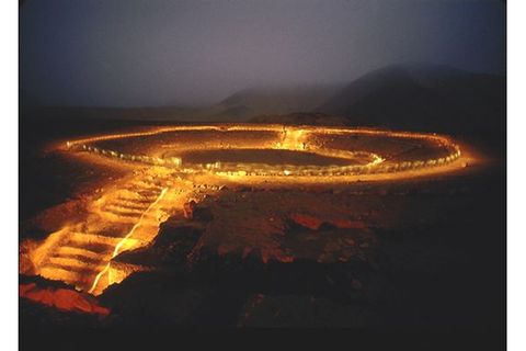Peru: Fackeln beleuchten das Ruinen-Rund des Amphitheaters von Caral