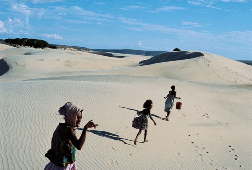 Urlaub: Sarodrano: Madagassische Mädchen laufen durch den weißen Sand zum Onilahy-Fluss, um Wasser zu holen