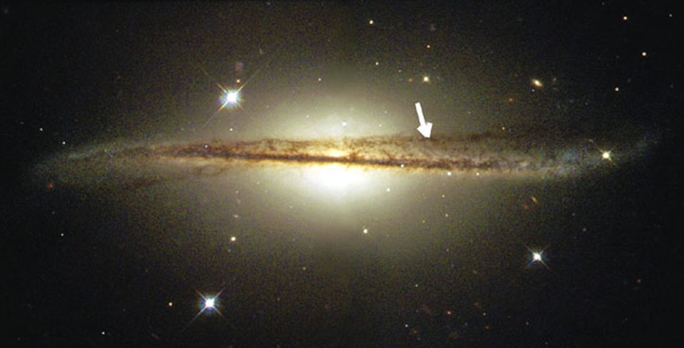 Galaxien: Ein Arm der Spiralgalaxie ist nach oben gezogen (Pfeil), möglicherweise durch einen Zusammenstoß mit einer anderen Galaxie
