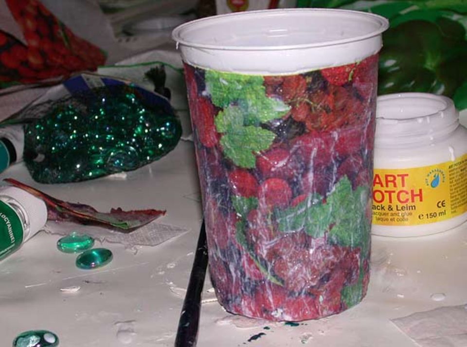 Upcycling: Die Serviette wird mit Lack-Leim auf die Dose geklebt