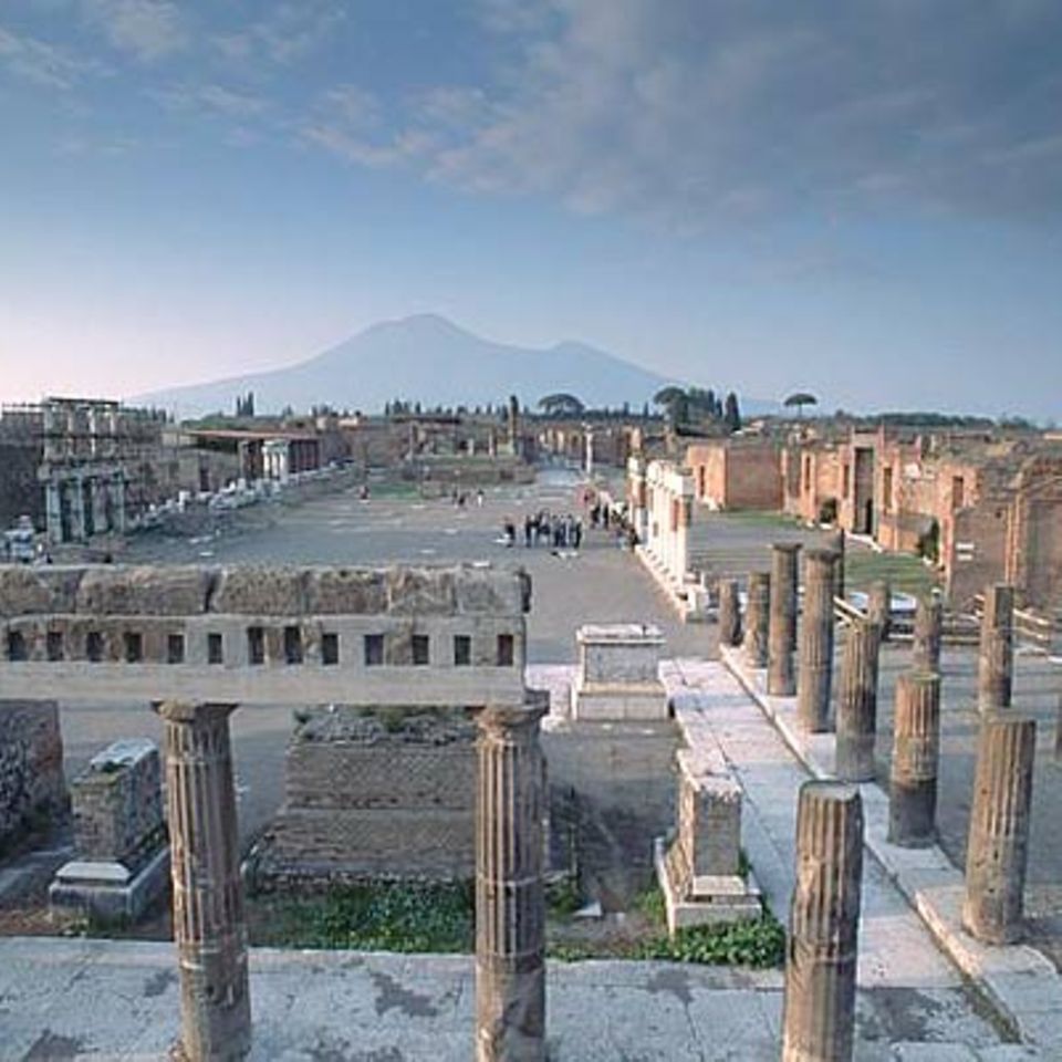 Pompeji: Das Forum von Pompeji. Als der Vesuv im Jahr 79 n. Chr. ausbrach begrub er die italienische Stadt unter einer meterhohen Schicht aus Asche und Gestein. Die Existenz von Pompeji geriet in Vergessenheit. Erst 1600 Jahre später wurden die Ruinen zufällig entdeckt. Die Ausgrabungen dauern bis heute an.