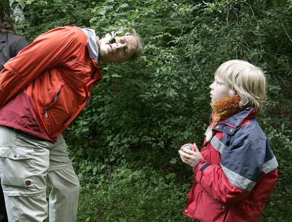 Carl aus der Kindergruppe des "GEO-Tages der Artenvielfalt" hat sich gerade mit seiner Becherlupe die Blattunterseiten angeschaut. Bundesumweltminister Jürgen Trittin tut es ihm gleich um den Baum bestimmen zu können