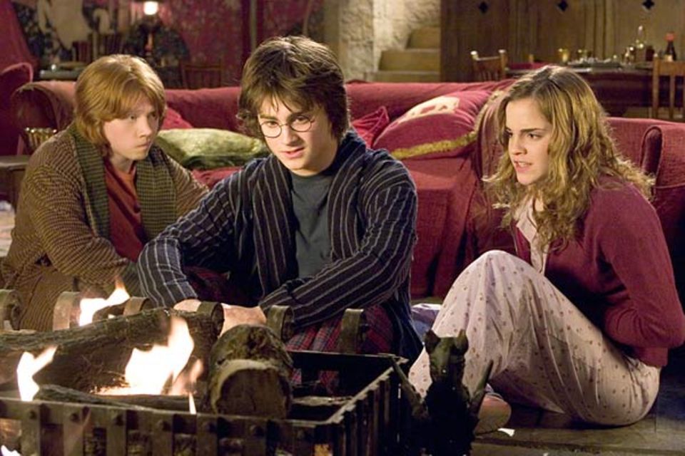 Fotoshow: Harry mit seinen beiden besten Freunden Ron und Hermine im Kaminzimmer der Zauberschlossschule Hogwarts. Sie beraten sich vor einer von Harrys schwierigen Prüfungen
