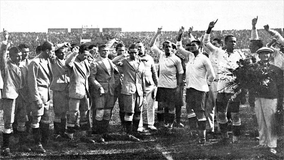 Fußball-WM-Serie in drei Teilen: Vor dem Endspiel der Fußball-Welltmeisterschaft am 30.07.1930 in Montevideo, Uruguay: Die Fußball-Nationalmannschaften von Argentinien (l) und Uruguay begrüßen winkend die Zuschauer Fußball-WM-Serie in drei Teilen: Vor dem Endspiel der Fußball-Welltmeisterschaft am 30.07.1930 in Montevideo, Uruguay: Die Fußball-Nationalmannschaften von Argentinien (l) und Uruguay begrüßen winkend die Zuschauer