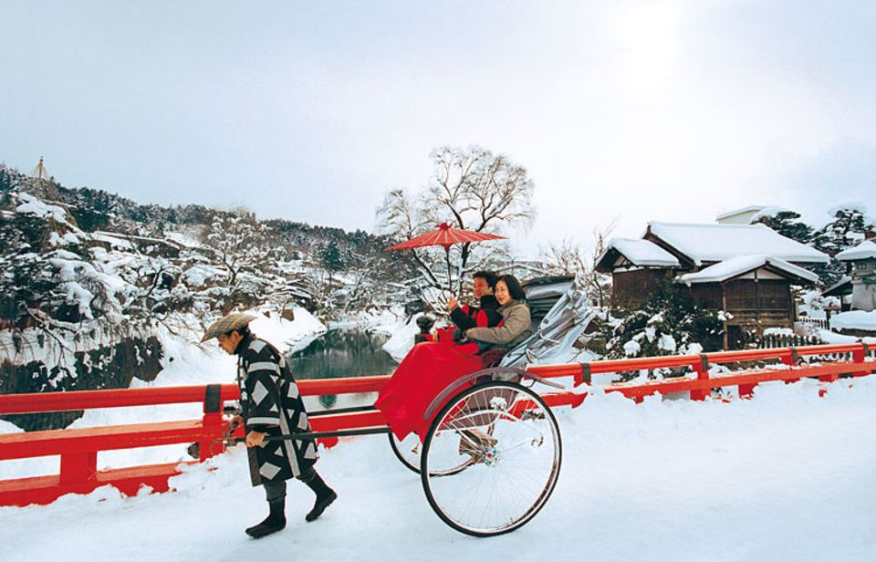 Japanischer Ziehweg: Abgeschirmt von jeglicher Hektik, genießen Touristen eine Rikscha-Fahrt durch die tief verschneite Bergstadt Takayama Japanischer Ziehweg: Abgeschirmt von jeglicher Hektik, genießen Touristen eine Rikscha-Fahrt durch die tief verschneite Bergstadt Takayama