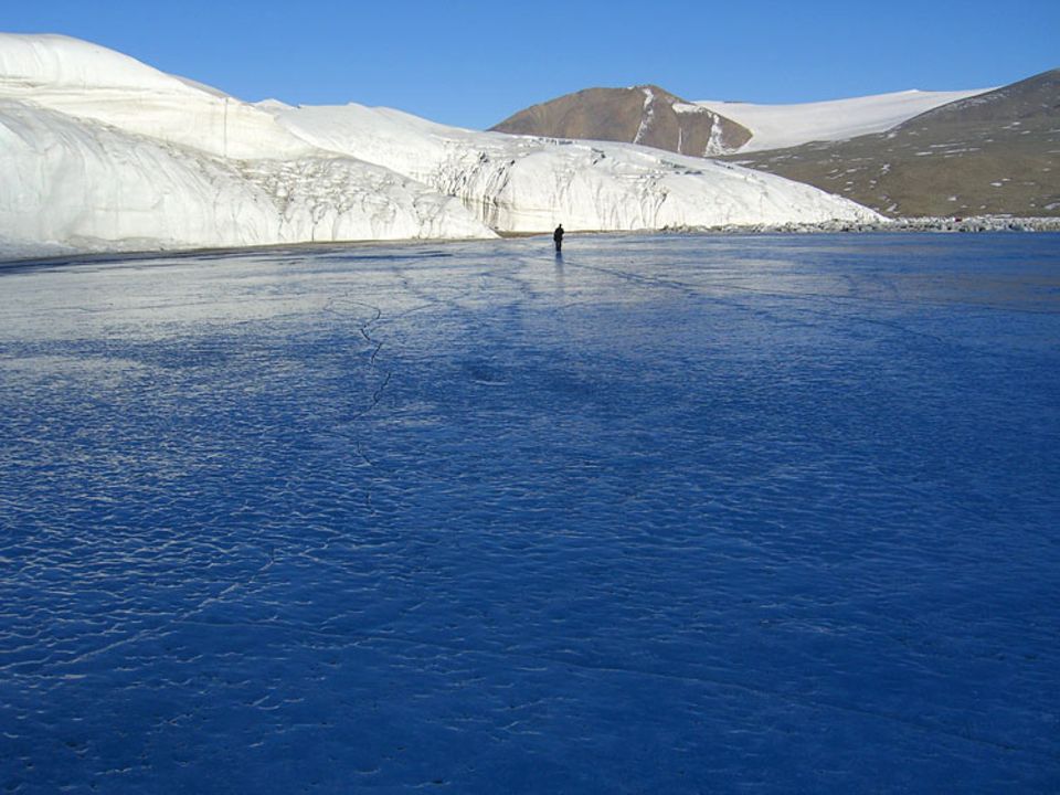 Als wäre Blau keine Farbe, sondern ein Gegenstand: Ein sonderbarer Spuk hallt immer wieder über die Eisdecke des Lake Hoare. Ein Ton, der entsteht, wenn das Eis unter zu hoher Spannung winzige Haarrisse aufsprengt