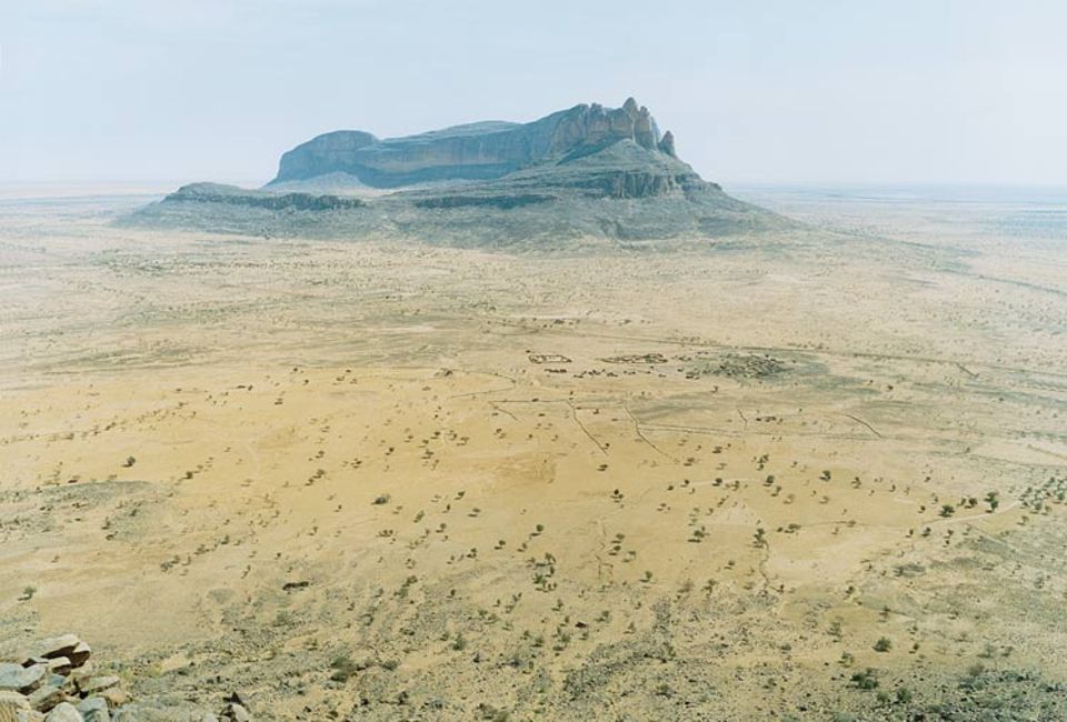 Mali: De Farbe scheint aus der Landschaft zu weichen, Sahel ("Wüstenufer") heißt der schier endlose Saum der Sahara. Wind und Sand fegen durch das Hombori-Gebirge, eine dürre, spärlich besiedelte Region mit gewaltigen Tafelbergen im Süden Malis