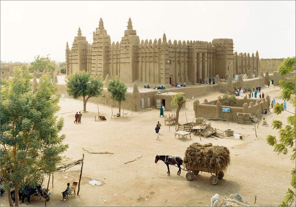 Mali: Zum Freitagsgebet versammeln sich die Gläubigen in der Moschee von Djenné - ein Bild wie aus lange vergangenen Zeiten. Der mächteig Bau erhält alljährlich einen neuen Lehmüberzug; als Leitern nutzen die Arbeiter die Holzbalken, die aus der Fassade ragen