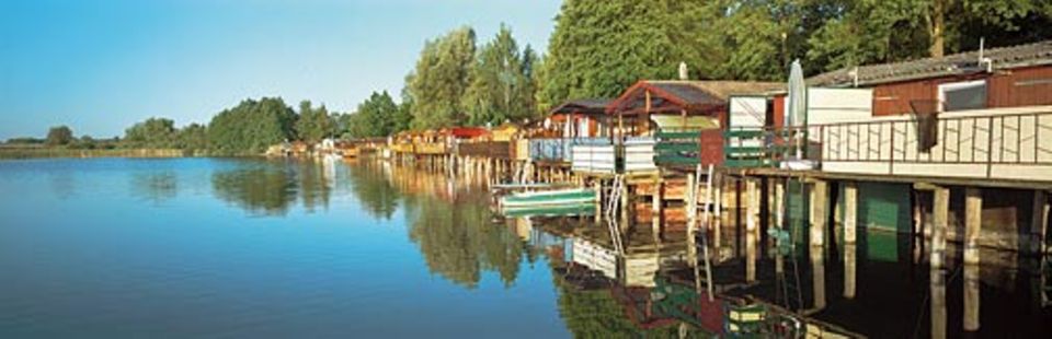 Mit stahlblauen Seen bezaubert die Uckermark: Pfahlhäuser säumen den Oberuckersee bei Fergitz