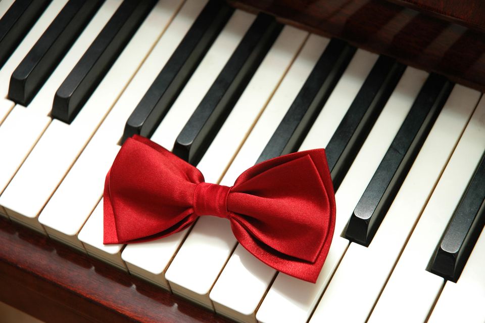 Rote Schleife auf Klaviertasten