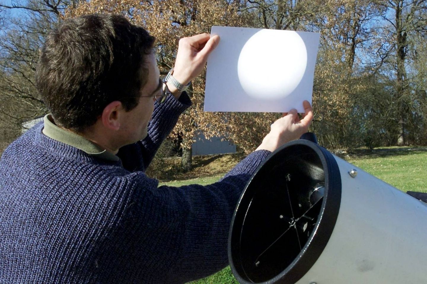 Ein Astronom zeigt ein Bild von einer Sonnenfinsternis auf dem Blatt