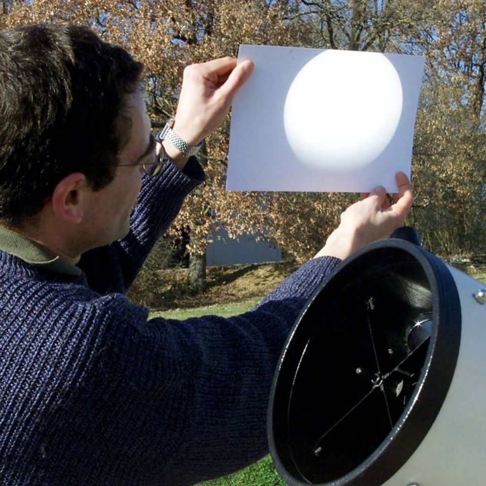 Ein Astronom zeigt ein Bild von einer Sonnenfinsternis auf dem Blatt