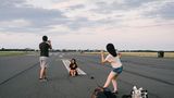 Touristen machen Fotos auf dem Tempelhofer Feld in Berlin
