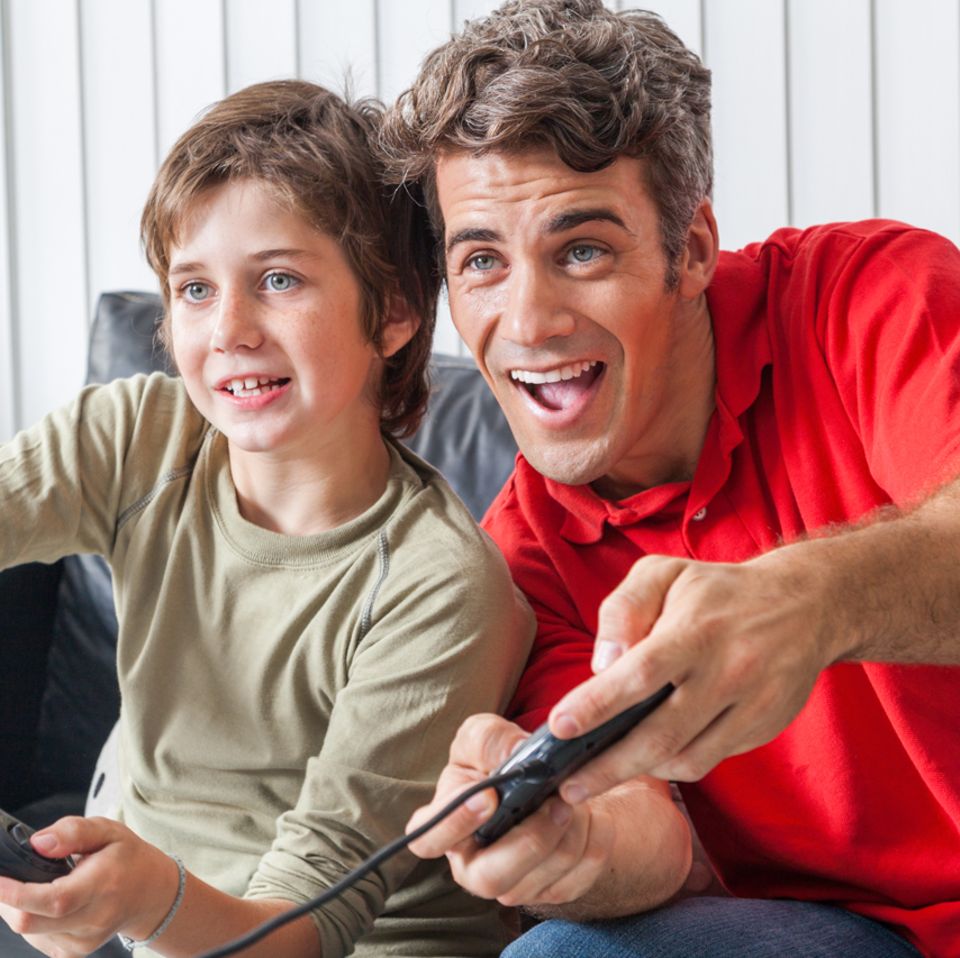 Familie spielt Videospiele auf der Konsole am Fernseher