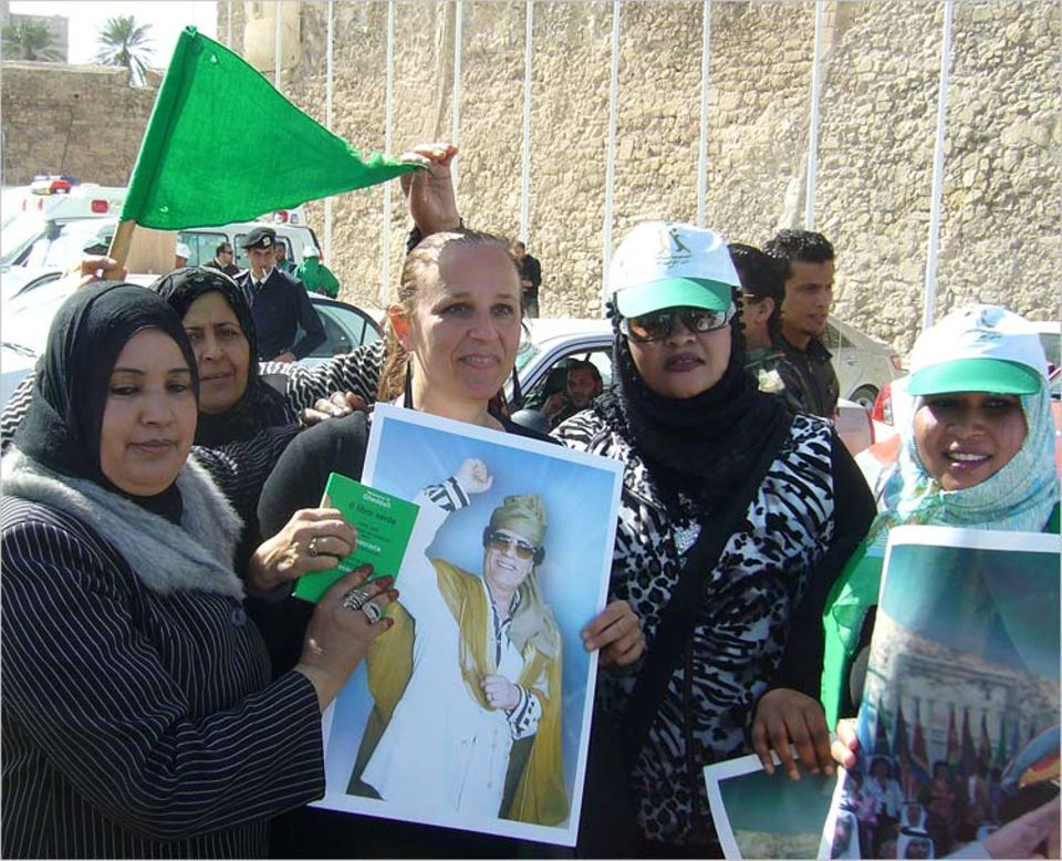 Unruhen in Libyen: Unfreiwillig nahm GEO-Redakteurin Gabriele Riedle in Tripoli an einer Pro-Gaddafi-Kundgebung teil. Das Foto des Diktators wurde ihr während der Demonstration in die Hand gedrückt – es war wohl das einzige Mittel, um der Verhaftung zu entgehen.