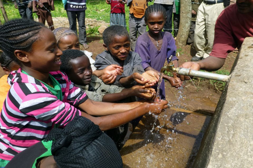 Die Kinder in der Gemeinde Tagera sehen im Oktober 2013 zum ersten Mal sauberes Wasser aus einer Leitung fließen Die Kinder in der Gemeinde Tagera sehen im Oktober 2013 zum ersten Mal sauberes Wasser aus einer Leitung fließen