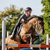 Henry und sein Pferd Selma springen über ein Hindernis