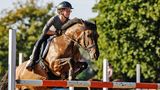 Henry und sein Pferd Selma springen über ein Hindernis
