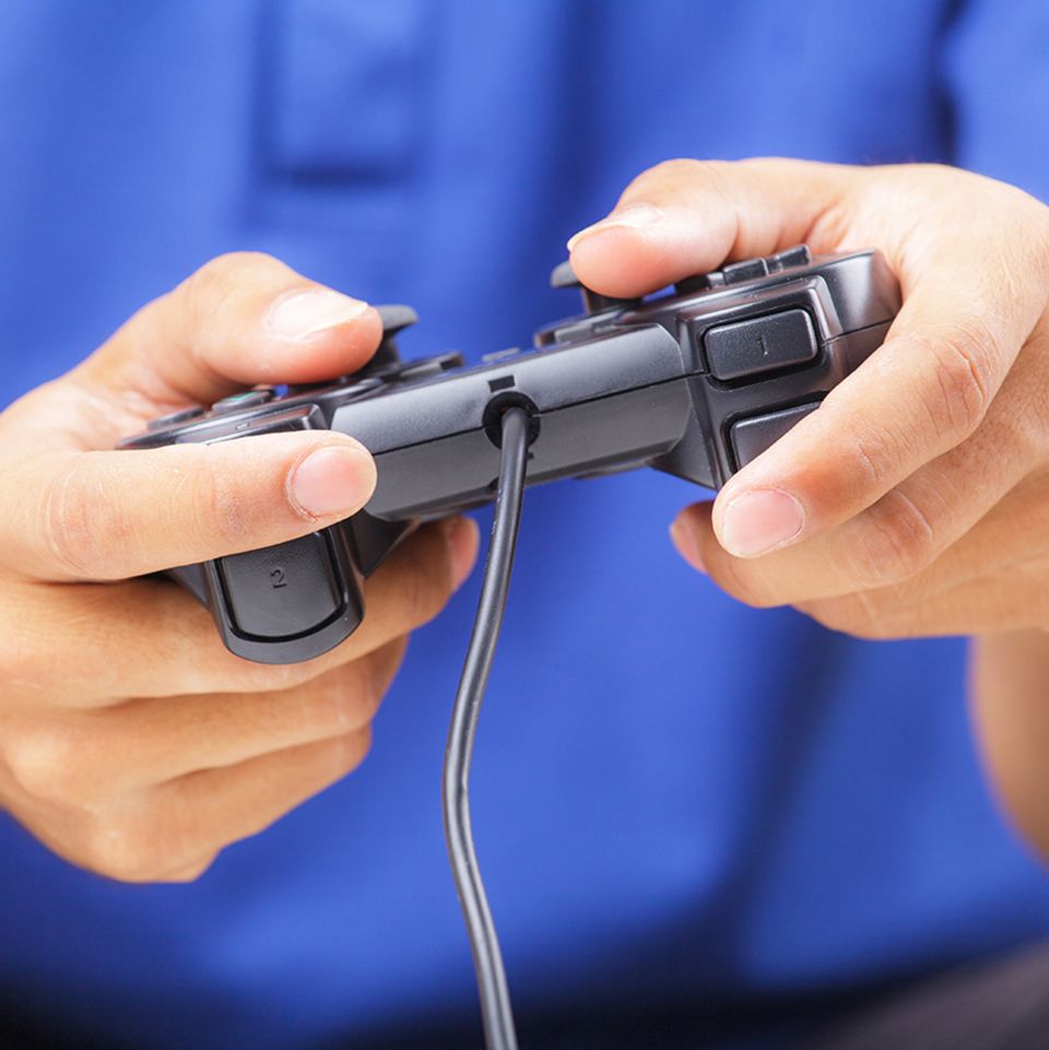 Mann spielt Playstation mit Controller