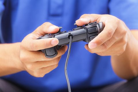 Mann spielt Playstation mit Controller