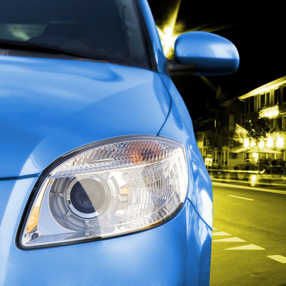 Ausschnitt eines blauen Autos, das durch die Nacht fährt