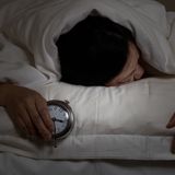 Frau hält Wecker in der Hand