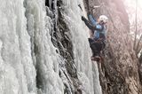 Eiskletterer klettert an einem gefrorenen Wasserfall, Alpbach, Alpbachtal