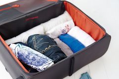 Gerollte Kleidung im Koffer